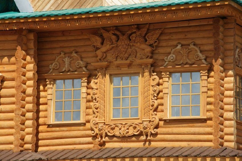 Plateaux sur les fenêtres d'une maison en bois: décoration supplémentaire de la façade